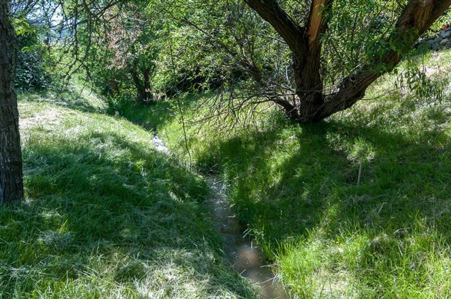 Beautiful half acre parcel, with level, usable, peaceful surroundings, gorgeous mountain views, a creek and T.I.D. irrigation! This property is not in the flood plain. Fema map has been changed! Just barely in the country with immediate access to shopping, schools and services. Perfect spot to build your gorgeous new home!