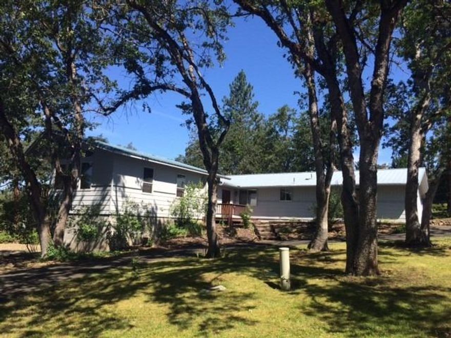 If county living is what you are looking for, this home and property fits the bill. Located in a park like setting with circular drive, beautiful flower beds and mature oak trees, with lots of open space to relax, garden and entertain. Ample parking space for RVs or toys in addition to the attached two car garage in front and attached car port in rear. Garden beds are deer fenced. Stalls and tack room have been converted to a shop with a cement floor, wired for both 220 and 110. Shop can easily be converted back to a barn. Eagle Point Golf Club right around the corner. Irrigation available from the Eagle Point Irrigation District. 2015 irrigation fees were $153.20 and are paid through the end of 2015.