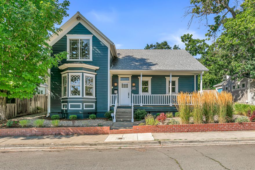 Nicely updated historic home located within three blocks of Ashland's downtown plaza and Lithia Park! All new Anderson windows, new sewer line, fresh interior and exterior paint, new doors, hardware, lighting, flooring, and carpets from 2022 through 2025. Main level with charming covered front porch, formal dining with bay window, two bedrooms, renovated full bathroom with tub shower, very spacious living room with sliding glass door to fully-fenced backyard, kitchen with new stainless refrigerator and dishwasher, laundry room with utility sink, and one-car garage. Rebuilt stairs with new banister to upper-level landing office or family room with glass door to expansive rooftop balcony, primary suite with built-in oak wardrobe closets, and full ensuite bathroom with new skylight, double quartz vanity, and shower with tiled surround. New paver patio, gazebo, outdoor kitchen area, garden studio, and gravel parking area with remote-operated gate to alleyway. Inquire for details!