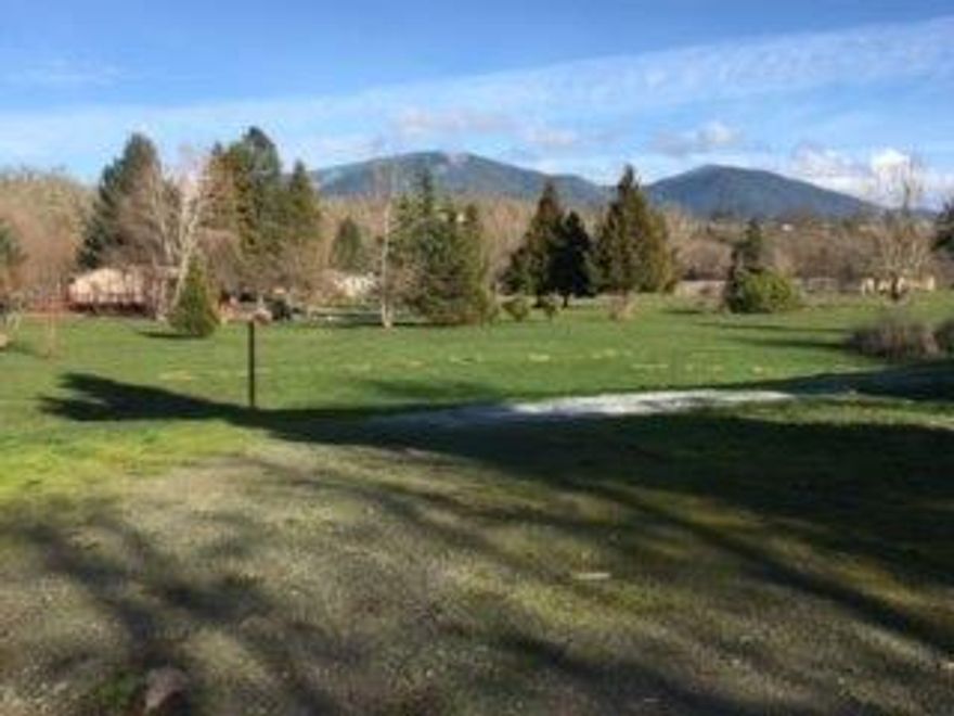 A multitude of opportunities awaits this beautiful, flat, property. It features a 1983 manufactured home that has been gutted; it was previously used for a honey business. It will take a lot of work to restore. Energy Trust of Oregon has a great program to assist in the cost of removing the home and replacing it with another manufactured home. The property is zoned for both residential and community use, offering a range of possibilities, such as an RV park, with excellent exposure on a busy road leading to the Rogue River.
Additionally, a shared well provides 30 gpm, ensuring an ample water supply. The property is large enough to move the homesite away from the busy road, to a quiet peaceful area of the 1.12 acres. Or a business closer to the road to take advantage of high visibility for customers. The choices are plentiful!