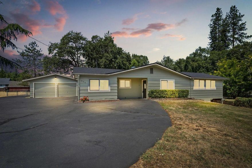 Below market - Mini farm or extra space! Completely remodeled in 2022 with new roof, windows, HVAC, water heater, cabinets, appliances, and paint; exterior repainted June 2024. Located at the end of a quiet road just minutes from town and near Schroeder Park on the Rogue River. Features 3 large bedrooms, a spacious family room, living/dining with fireplace, breakfast nook, and laundry with abundant storage. Main bath has tub/shower; primary has half bath. Oversized 2-car garage plus second driveway with RV parking and carport. Large, flat pasture with 540 sf barn (new roof 2024) with stalls, chicken coop, hay loft, and garage. Also includes 880 sf building with shop, storage, and 2-car garage (roof ~5 yrs old). Irrigation rights from Grants Pass Irrigation. Former pool area ready for new installation. Block walls keep home cool in summer, warm in winter. 2-family potential—owner may sell adjoining .92-acre lot.