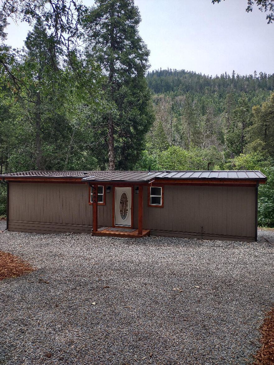 Possible Owner Carry with large down. Beautiful waterfront property. Completely remodeled 2 Bedroom and 1 Bath double wide manufactured home 704 sq. ft. on a very private 1.67 acres backed up to BLM. Relax by the year round creek on a 180 sq. ft. covered cedar deck. This home has a new 50 year metal roof, new paint, new doors, new plumbing and electrical fixtures, shaker style doors, windows, energy efficient ductless heating unit with splitter, hickory cabinets, granite countertops, W/D hookups, and all new appliances. Beautiful fenced property, quiet and peaceful living, plenty of room to park a motorhome. Move in ready and enjoy the sound of the creek. Terms are cheaper than renting.