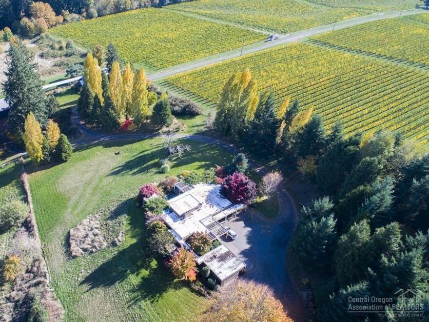 Surrounded by rolling hills, vineyards, orchards and gardens, lies your private Oregon wine country estate. Over 40 acres of spectacular beauty. The main home features floor to ceiling glass that allows you to experience the outdoors from every room. Easy maintenance lap pool that is covered with a wisteria wrapped veranda. Additional structures include a separate guest quarters, office, art studio, workshop, barn and second garage.