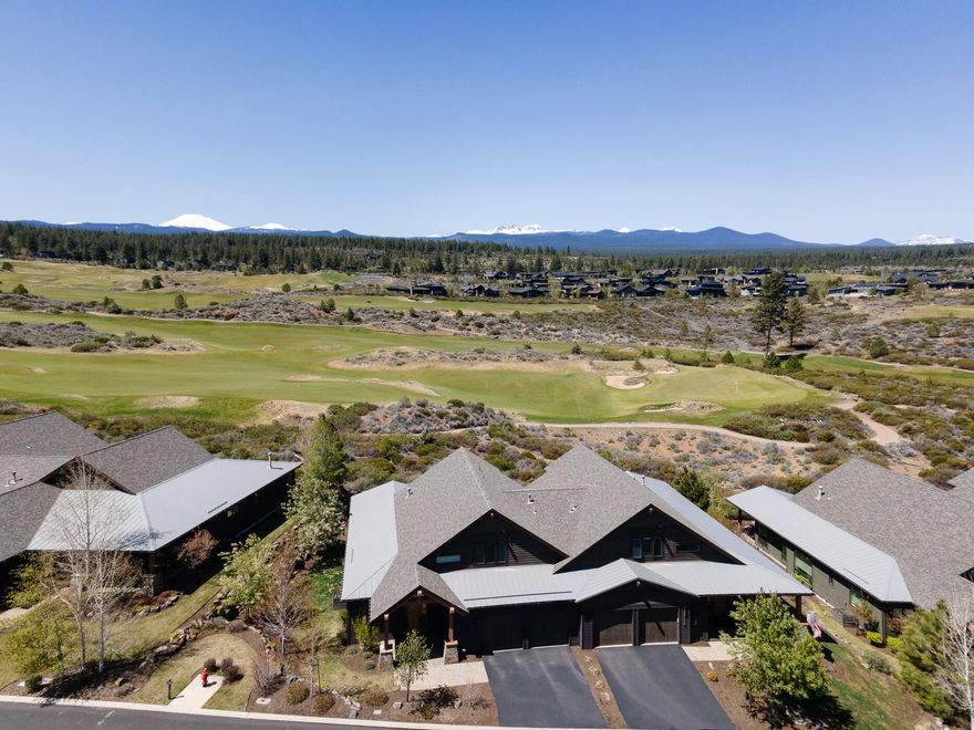 Experience lock & go living in the desirable neighborhood of Triple Knot at Tetherow Resort. Perched on the ridge of the 10th fairway, this light & airy townhome captures picturesque views of the Cascades & Tetherow golf course. The well-thought-out floorplan features a main level primary bedroom & office, w/two additional en-suite bedrooms upstairs. The open great room is perfect for entertaining, featuring a chef's kitchen w/double islands, high end cabinetry, & quartz counters w/an additional prep sink, built-in speakers in the kitchen, great room, & patio, hardwood floors throughout most of the main level, & a gas fireplace w/metal accents & elegant built-ins.  The primary suite features a spa-like bathroom w/a double vanity, walk in closet, soaking tub & a tile shower w/dual heads. With true turnkey living, you'll have time to enjoy the peaceful & private setting from the expansive, partially covered patio, the resort facilities, & the close proximity to Bend's westside amenities