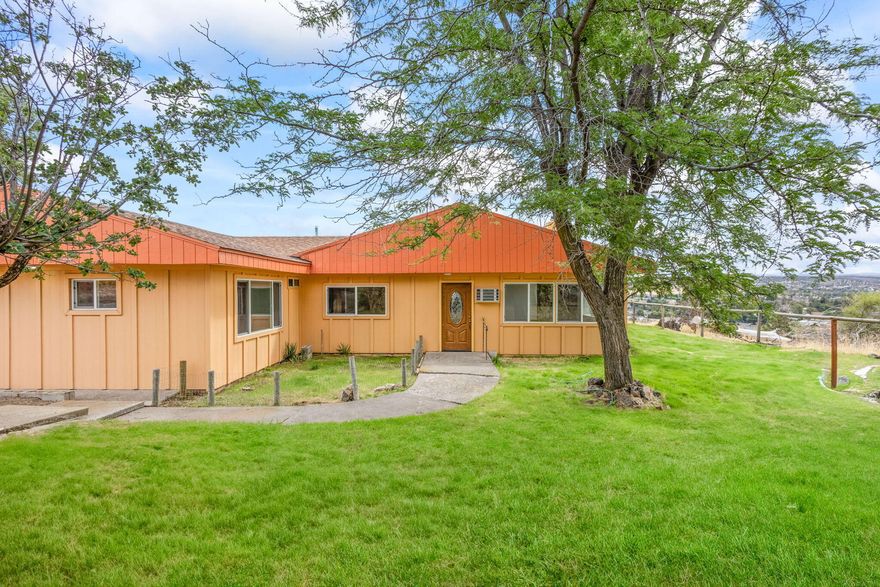 Almost half an acre looking out on the city of Madras and the surrounding territory.  Out of town, yet close to town.  Giant living room with abundant windows to soak up the views.  Updated kitchen.  Primary suite has a bathroom and two rooms to enjoy.  Seller offering up to $10,000 for carpet and other upgrades. This home has ample living space.  If you want a killer view and a lot of living space at a reasonable price, this house is perfect.