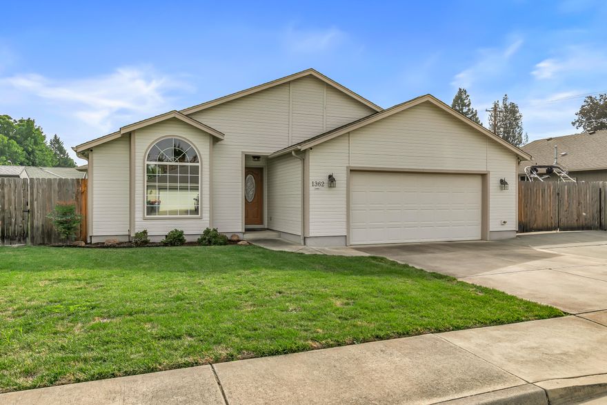 Incredible Central Point location tucked away in a quiet setting, this immaculate home is move-in ready with beautifully maintained yards front and back. Enjoy real oak hardwood floors, vaulted ceilings, crown molding, solid wood doors, custom paint, and plenty of natural light. Wonderful floor plan features a spacious primary suite with walk-in shower, dual sinks, and large walk-in closet. The kitchen shines with granite counters, undermount sink, stainless appliances including refrigerator, and custom cabinetry. Additional highlights include a jetted tub in the guest bath, tile in laundry and baths, recessed lighting, upgraded windows, and extensive storage throughout. Outside offers a large covered patio, paved RV parking, in-ground sprinklers, and two storage sheds including a custom shed with power. The oversized two car garage includes built-in cabinets and workbench. This property has been meticulously cared for inside and out and is truly priced to sell.