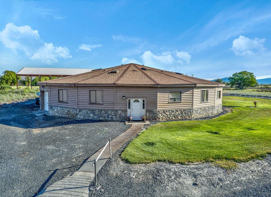 This property has more of everything!  Starting with 11.74 acres, a 80'x160' pole barn, a 20x40 garage/shop and a unique 5,000 sq ft round house with 5+ bedrooms and 3 baths. The interior circular living room is HUGE with vaulted ceilings, skylights and beautiful solid surface floors. Open kitchen/dining areas, and expansive recreation room.  The main bedroom, has a separated room, great for an office or nursery. Both the master and rec rooms open out to a courtyard area. There is also an attached single car garage with shop area.  The newer well-constructed pole barn has, a compacted raised pad already in place and could easily accommodate a second level. There is a ''fire lane'' access road that circles off Joe Wright Rd back around to Hwy 97. In addition to all this there is a good sized pasture area with KID Class A water rights. This property offers SO MANY options for multiple uses.
