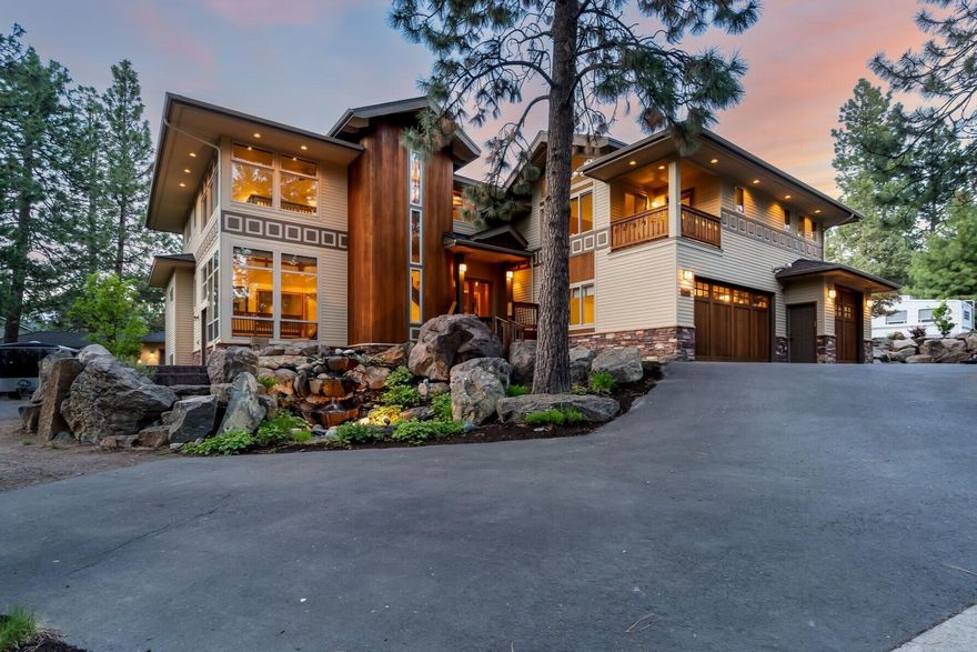 Truly a one of a kind custom home, this Craftsman style gem is situated on a corner lot on Bend's west side, just minutes from downtown. Nestled into a spectacular bouldered landscape w/serene waterfall at entry. Luxury finishes throughout w/2 story west facing atrium, travertine floors & cozy wood finishes. Well-appointed central kitchen w/granite, SS appliances & ample storage. Open living & dining w/gas FP, art lighting & sound. Primary Ste boasts atrium views, private deck, attached den. Walk in shower, soaking tub, dbl sinks in bath. Lower level offers 2 add'll Suites w/kitchen & living spaces & huge laundry rm. Lockoff ADU over garage w/outside entrance is 1 br, 1 bath w/kitchen & living space - perfect for family, friends or income potential. An artist's dream, upper bonus area ftrs extra storage & drying space. Radiant floor heat, A/C, central vac- ask for amenities list! Oversized 3 car attached garage, additional 2 car & shop space in NW corner. RV parking, no HOA! New Roof!