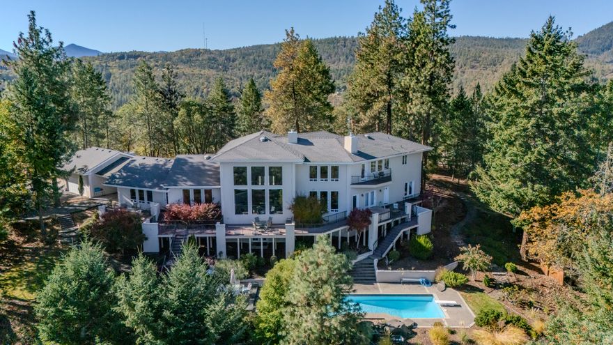 Just 2 miles from Jacksonville, this stunning hilltop estate blends elegance, privacy, and craftsmanship on 20 forested acres. This home showcases panoramic views from nearly every room. The soaring 28-ft ceilings and wall of windows create a dramatic entry. Chef's kitchen features granite counters, custom maple cabinetry, walk-in pantry, and is open to both a formal dining area and expansive great room. Main level includes two spacious guest bedrooms with private decks, office, family room, mudroom, and multiple baths. Upstairs, the primary suite boasts, private balcony, bonus area, walk-through closet, fireplace, and spa-like bath with jetted tub overlooking city lights. Additionally, is a 970 sq ft finished basement with bonus rooms. And a 3-car garage, carport, circular driveway. Enjoy outdoor living with a wraparound deck, hot tub, pool, patio, and water feature.