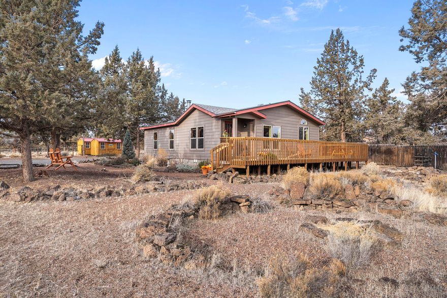 Welcome to your Central Oregon horse haven! This cozy, impeccably maintained home rests on 5 private acres backing to the North Unit Canal, just 10 minutes from amenities in Redmond. Equestrian-ready, the property features a Paddock Paradise setup for the health of your equine friends, three Old Hickory sheds, hay storage, a dedicated horse shelter, cleaning station, and abundant space for future outbuildings, round pens or a greenhouse. Enjoy the convenience of a private well, a garage space with carport and extra storage, and nearby access to public lands and trails for endless outdoor adventures. A large wrap-around deck is perfect for entertaining or a relaxing morning cup of coffee. Inside, relax by the cozy wood stove, appreciate an airy vaulted ceiling, and bask in an abundance of natural light. Bring your horses and your dreams—this property is ready for your next adventure!