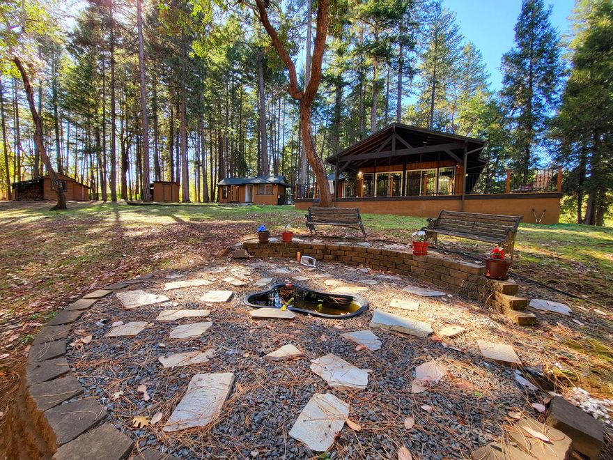 Welcome to this estate all gated and ready for move in. Two private entrances as another tax lot is included with this property. Main house has 3 bedrooms, one of which is used as a den. Knotty pine ceilings, large windows that overlook covered patio deck. This is a two family setup in which you have two outbuildings that are setup for guests. Lots of other extra buildings for storage and equipment. Great shaded areas and a relaxing atmosphere indeed. Please visit to see all this home has to offer as this is not a drive by. Seller has done a lot of work to get this ready for the next homeowner. Large Garage/Shop and some equipment left on property can be negotiated with offer. Addition tax lot has fenced in Garden area and is a separate tax lot with entrance and it's included.  So many possibilities for a home business or two family/guest setup. Areas for shop and garden areas.  Entrance is second gate with real estate sign. Make offer! All information deemed accurate, not guaranteed