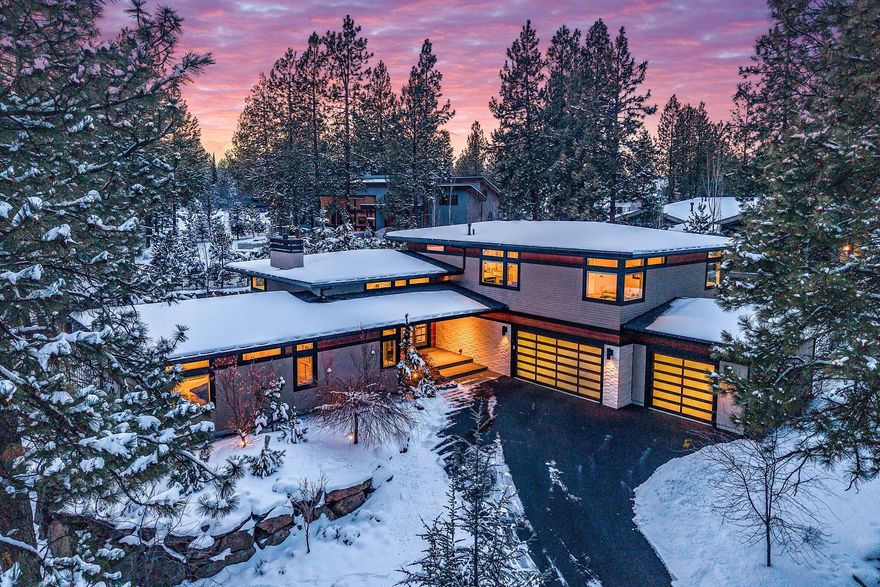 Discover contemporary elegance in this stunning Shevlin Ridge residence, masterfully designed by renowned architect Brandon Olin. Set on a beautifully landscaped .32-acre lot, this architectural gem blends sophistication with natural serenity. The striking exterior features clear cedar siding with island stone accents, hinting at the refined design within. Inside, expansive open living spaces are bathed in natural light from custom transom windows. DuChateau oiled white oak flooring, bespoke lighting, and a dramatic limestone fireplace create understated luxury. The gourmet kitchen boasts Wolf appliances, a Sub-Zero refrigerator, sleek European cabinetry, and a walnut-accented island perfect for gathering. Thoughtful details abound—custom walnut built-ins, abundant storage, and an oversized 1,260 sq ft three-car garage with a dedicated dog-washing station. Multiple outdoor entertaining areas include lush landscaping, a cozy firepit, tranquil water features, a built-in BBQ. and more.