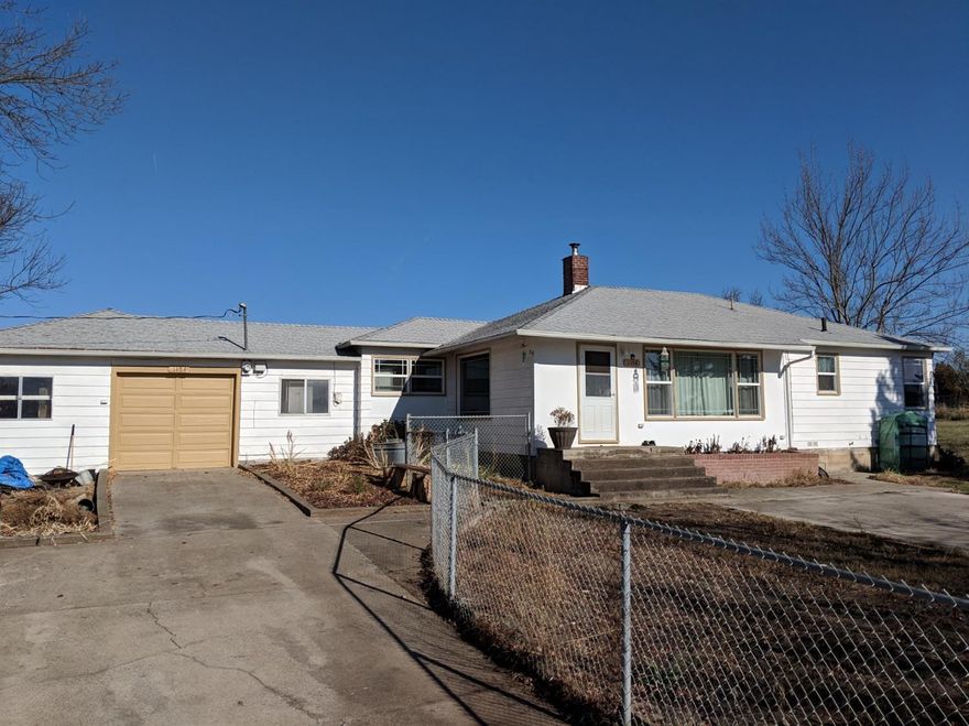 Charming home on a little land in a quiet neighborhood! Fully irrigated, and cross-fenced means it's ready for livestock or crops, and the copious amounts of fruit trees will make for a very bountiful harvest season! This 4 bedroom, 1 bath home is a great home for a family. The wood-stove insert in the fireplace keeps the house warm in the winter, and the layout is great for kids or a good size family. There is a wellhouse in back with extra storage space. A large workshop and attached garage make for great project areas, while the spacious kitchen has all the room you would need to entertain and cook meals of any size.