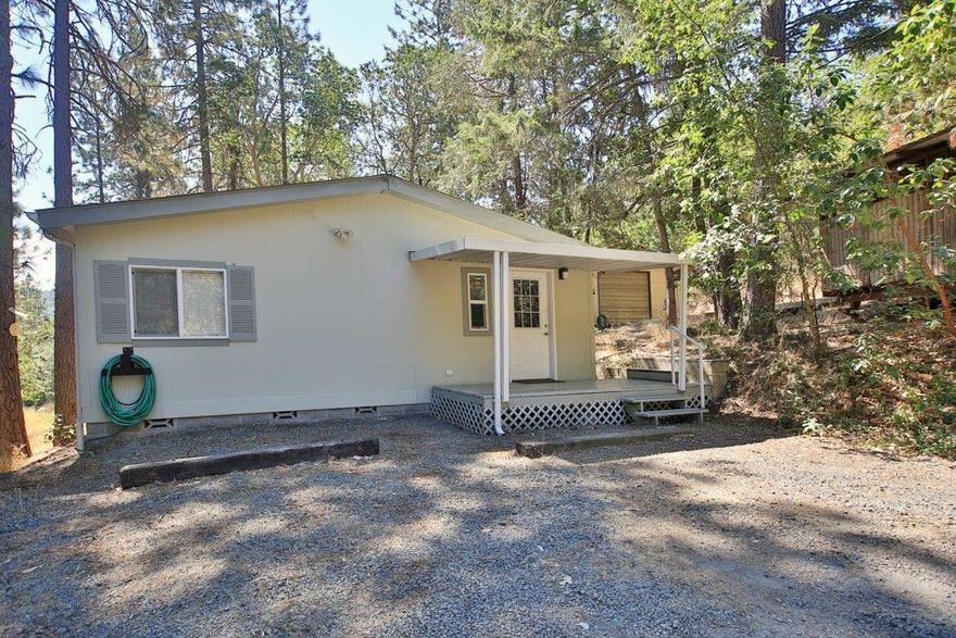 This is it! Tucked away on 2.07 treed acres! Clean Manufactured Home 1188 sq. ft. desirable split floor plan! Living room has front door entry and a large picture window! Open Kitchen concept is light and bright with Vaulted ceiling and island for extra work space, cabinet pantry and lots of storage! Kitchen incorporates dining area and is open to living room. Laundry room sits off from kitchen with door out to parking area. Shop/garage sits on tiered upper level close to home but has own driveway. Front yard is treed and gives a great space!