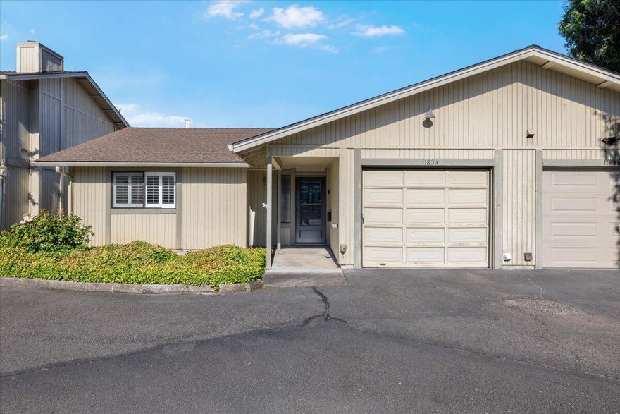 This charming single-level 2-bedroom, 2-bath end-unit condo features a spacious foyer with a large closet, a step-down living room with a cozy gas fireplace, and a well-appointed kitchen that includes all appliances. The interior has been freshly painted and offers laminate and vinyl flooring throughout. The primary bedroom includes a built-in dresser and an en suite bath with a walk-in shower, while the hall bathroom offers a classic tub-shower combo and single vanity. The washer and dryer (included) are located in the attached garage with additional built-in storage. The backyard offers a retractable awning and a potting workspace - perfect for gardening or relaxing. Convenient East Medford location near shopping, dining, and schools.