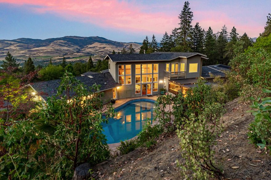 This one-of-a-kind haven offers seclusion and serenity within easy reach of downtown. Contemporary design with flowing floorplan is light-filled and surrounded by park-like acreage suited for full-scale entertaining, quiet retreat, work-from-home, cultivator's delight, or all-day relaxation. Expansive valley views from living areas are complemented by the privacy of the pool, outdoor kitchen, fire pit & quiet gardens opening into the backyard. The well-appointed chef's kitchen is the heartbeat of open living, dining & family rooms. Laundry, powder bath, storage and exercise/office areas are adjacent. Upstairs master presents luxe comfort. Large bedroom with space to lounge, 2 bathrooms & separate glass-walled euro-spa soaking tub. Downstairs are 3 additional bedrooms. 2.5 bathrooms w/a separate access for entrance if desired. Gated circular drive winds throughout the lower gardens, fruit trees & greenhouse to arrive at this exquisite sanctuary.