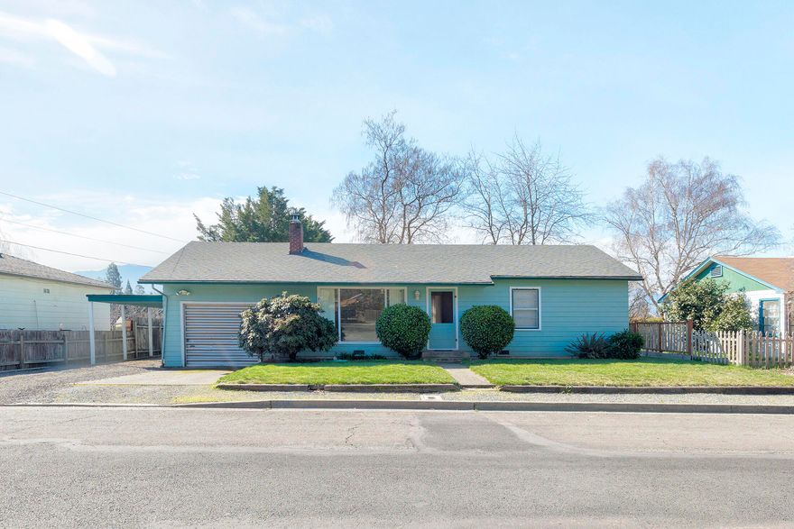 Don't miss this charming cottage before it's gone.  It features original hardwood floors, deep closets and a giant picture window in the living room.  One car garage plus a carport and driveway give able parking space.  The large backyard is a huge bonus with big, mature trees and privacy vines and a shop with a wood shed and multi-purpose room with electricity and heat.  Exterior of house was repainted within the last year.  Close to schools, downtown and shopping.