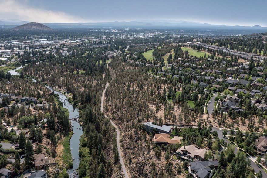 If you have ever dreamed of watching Central Oregon's finest sunrises while overlooking the Deschutes River... this will be your home! This custom built home with it's modern style, offers an abundance of natural light throughout with large scale windows on all sides. The main living, dining room and kitchen come together on all sides with beautiful windows, skylights, sliding patio doors, built-in cabinetry and the finest kitchen appliances. The master is on the main level with a large and luxurious bathroom. This is a room that you will never want to leave!  Also on the main level is the gym that could also double as a fantastic office space. Upstairs there are three more bedrooms and a large sunny patio overlooking the property. The surrounding outdoor space is perfect for entertaining. The sunken hot tub is a perfect addition to relax outdoors. The private paver driveway is heated and the oversized four car garage has been thoughtfully designed. Located on Bend's desirable Westside