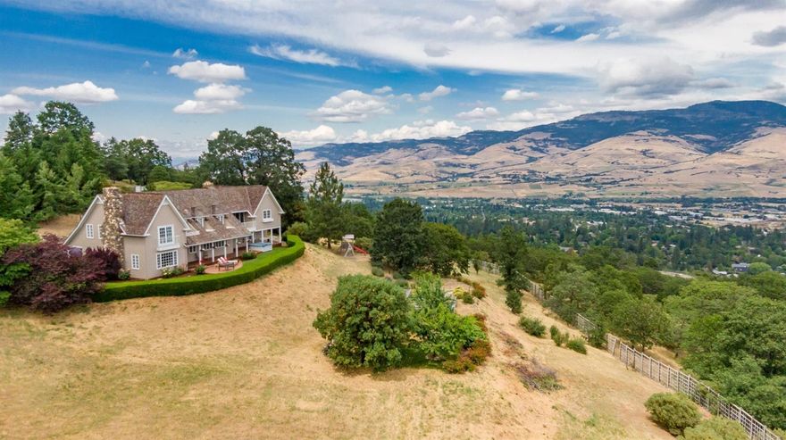 Panoramic views of Grizzly Peak and the surrounding valley await your entry onto the landscaped grounds of this stunning Cape Cod-style home. Entertain guests from the large outdoor patio as they admire the fruit trees and rose bushes in the garden. Character and craftsmanship abound, with gleaming hardwood floors, custom built-in storage, and dramatic vistas throughout. Large gourmet kitchen features all-new Bosch induction cooktop and convection oven, and new granite countertops. Abundant natural light floods the entire home, especially the open concept living spaces. Both the living room and kitchen feature river rock fireplaces. The spacious master suite offers an adjacent studio with a private balcony, and a clawfoot tub in the marble-tiled master bath. Second-floor bonus areas are perfect for use as a playroom, library or exercise room. Enjoy privacy and tranquility with gated entry in a very desirable neighborhood, just minutes to town.
