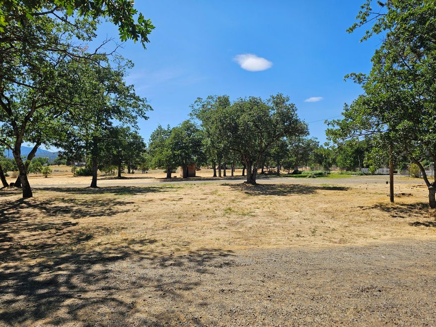Located in the heart of Sam's Valley, this flat very useable 5.15-acre property is ready for you to develop your dream. The property is zoned EFU so the taxes are low and the previous home established the home site that includes a strong well (per seller), septic system, power and roadways. The property has excellent sun exposure, the front portion is sprinkled with oak trees and the back is open field which could accommodate livestock, crops or??? Additionally, there is an approximately 2400 square foot barn/workshop with power, sewer, water, stalls and a small un permitted living space with living room, kitchen, bathroom and bedroom. Bonus, there is a small building that needs some work but has power sewer and water connected as well. For recreation it is located a few miles from the famous Rogue River and Table Rocks. The country store is minutes away and 15-20 minutes to the airport, shopping, medical and restaurants.