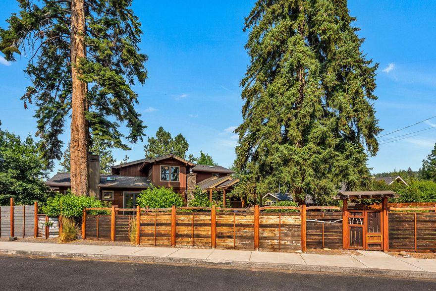 This masterfully updated 2,588 sq. ft. home offers 2,060 sq. ft., 4 bedrooms/2.5 baths in the main home and a welcoming 528 sq. ft. ADU forming a quiet retreat on an oversized lot in the heart of Bend, close to the river, downtown & westside amenities. The open great room overlooks a tranquil waterfall pond and features floor to ceiling windows, tile fireplace and expansive, modern kitchen with enormous center island & gas range. Incorporated from the original cottage, the primary suite centers on a hand built rock fireplace & beautiful bath with tile and stone shower, soaking tub & walk in closet. An efficient main level floor plan also includes a 2nd bed/office with direct access to the yard. Two guest bedrooms and full bath complete the second level. With a separate entrance, private balcony, gas fireplace & laundry, the 2nd story ADU provides potential income or the perfect hideaway for your guests. Fully fenced & landscaped, this is a captivating, one-of-a-kind property