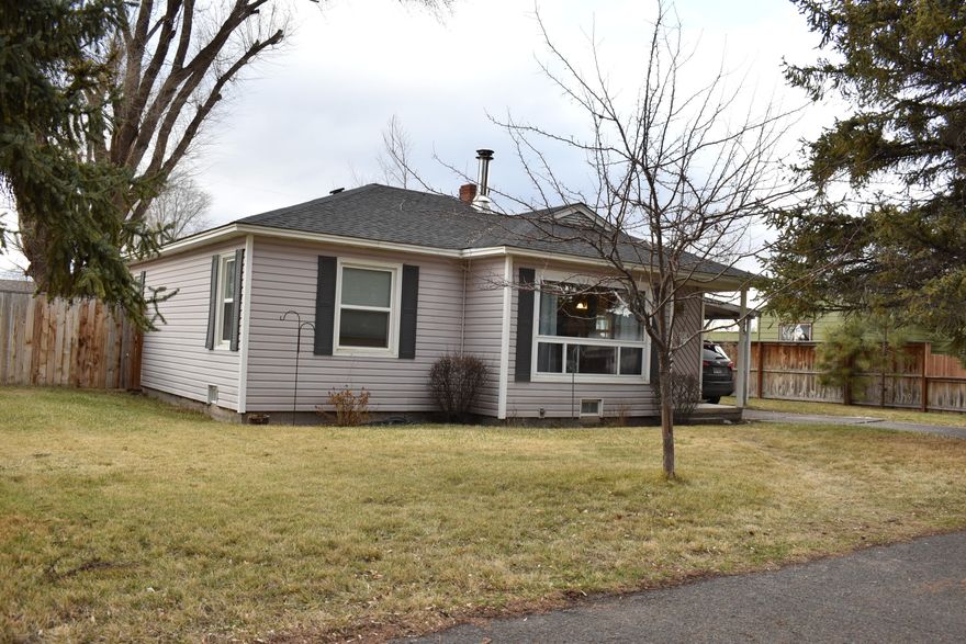 Very cute, well cared for 2 bed, 1 bath home in quiet neighborhood. Close to schools, fairgrounds, parks, dog parks and shopping. Original hardwood flooring throughout living, dining, hallway and bedrooms. Larger bedroom is carpeted, but has original hardwood flooring underneath. Large fenced back yard with storage shed on concrete pad. Stay warm in the winter with the wood stove and a natural gas furnace. Concrete driveway and attached carport. Great opportunity for homeowners or investors!  Don't miss out on this one! Call today to schedule a private showing!!