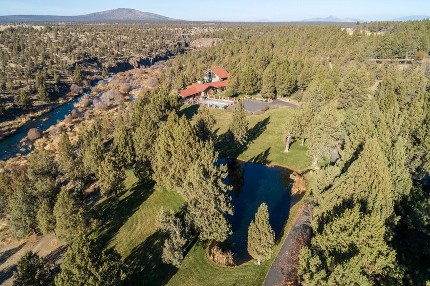 Deschutes River Estate with an estimated 3/8 mile of private, unobstructed river frontage and located at the end of a secluded private paved road. This is an once in a lifetime property with 20 private acres, 10 irrigated acres, mature landscaping that has been beautifully maintained as a park like setting, 2 ponds, barn, separated fenced lower pasture, the property is fenced with gated entrance. The single level home with 5 bedrooms, includes large open living space,
separate flex space above the garage, four car garage, swimming pool and covered deck overlooking the Deschutes River. Easy access to the raging river and calm eddies. Opportunity to own a property on the Deschutes River minutes from Tumalo and short drive to Bend.