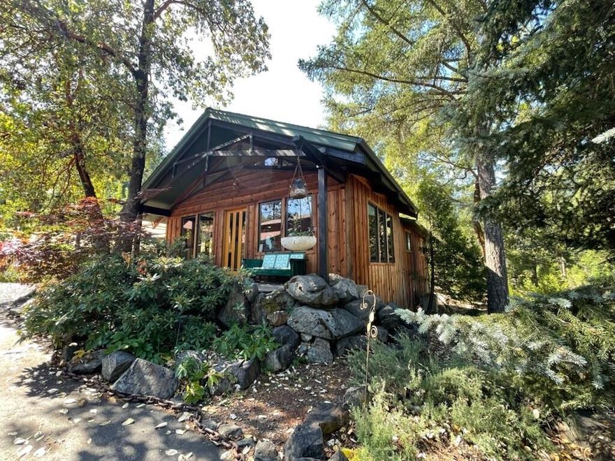 If you're looking for a shop, then this is the property.  Features an artsy NW designed home with 3 bedrooms, 2 baths, that's approx. 1200 sf. This home has vaulted ceilings, skylights, and a built-in entertainment center in the living room with hardwood floors. The kitchen has slab granite tile counters, custom knotty alder cabinets and an eating bar. Primary room has wainscoting and hardwood floors, walk in closet, with a primary bath that has custom pedestal sink and cherry cabinets. The hall bath features ship lap and the guest bath has cultured marble tub/shower combo and ship lap trim. There are solid wood doors with glass knobs on some of the interior doors. There is a covered front porch with a hand carved post, 2- 2 car garages one with a partially finished room upstairs that has lots of possibilities, as well as another 24X40 shop with insulated walls, 12 ft doors and propane heater. The home is situated in the middle of 5 private wooded acres with some fruit trees.