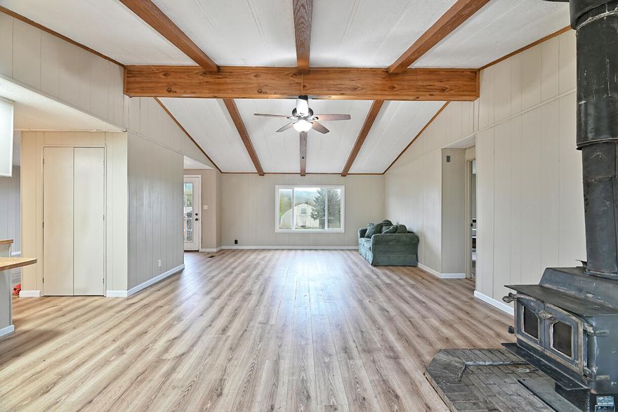 Financing is available! Experience the beauty of country living w/this beautifully renovated, turnkey 3 bedroom, 2 bath home. Featuring new laminate & vinyl flooring throughout most of the house, fresh paint inside & out, this home is ready for you to move in! The open-concept design boasts vaulted ceilings & a great room w/ a cozy wood-burning stove. The kitchen, complete w/ a breakfast bar, flows seamlessly into a space that can serve as a formal dining room or an additional living area. The split floor plan offers a private primary suite w/ a double vanity, walk-in closet, & plenty of natural light. The home is equipped w/vinyl windows & maintained heat pump, w/ recent freon service in October 2024. Step outside to a brand-new 12x44 deck, perfect for entertaining or simply soaking in the stunning mountain & countryside views. Includes its very own greenhouse w/ separate power meter. Welcome home!