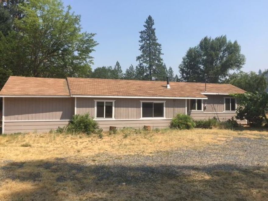 Charming, sunny home with large, turn-key garden in a quiet area of Williams. Set back behind fruit trees (apple and pear) and grapes, this cozy home awaits it's next people. In addition to the 3 bedroom, 1 bath home, there is a enclosed shop area,and established garden area. Good producing well (16.5 gpm) with newer pump and pressure tank. New carpeting in the two larger bedrooms. Recently painted living room. Third bedroom has an additional office or den space. Private back yard area. Great mix of trees and meadow, with beautiful mountain views.