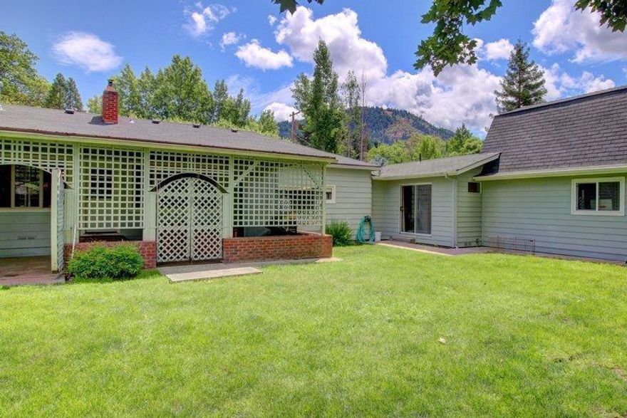 Located on a private lane that ends at the Rogue River, this home has been meticulously maintained and improved on every year by the current owner. The kitchen shines with newer cabinets and counter-tops. Step through French doors with beveled glass and crystal door knobs into a large room with cherry hardwood flooring could be a family room, theater, or possibly a master bedroom. The garage/shop has separate heat/AC and there is a finished bonus room (included in SF) above it. There is so much to enjoy on this large lot covered front porch, covered back patio, hot tub, completely fenced and room to park a 40' RV surrounded by lush lawn and mature trees for your relaxation pleasure. Close to Portola Park with tennis courts and soccer fields, you will love the location and all it has to offer. See this gem today- Call for your personal tour.