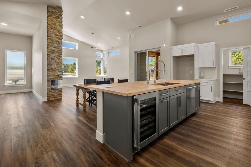 Newly built mid-century beauty in Sisters! This home combines asymmetrical rooflines and contemporary style. The 3BR, 3BA model features 2 suites and boasts a floor to ceiling stone fireplace in the great room. The amazing chef's kitchen includes extensive counter space, under cabinet lighting. rollout cabinets, a 5 seated island, beverage fridge plus a walk-in pantry. There is access from the dining area to a private covered patio for outdoor dining. The primary suite has a soaking tub, curb less shower, walk-in closet with built-ins. Frameless shower glass in all baths. This 2188 sq ft home has so much to offer, including signature artisan fencing on a big 9,440 sf lot! Photos feature a different Columbia Model and are shown as an example of home. Color palette of home for sale includes white cabinets, white quartz counter tops and tile, butcher block island, warm slate look stone on fireplace and gorgeous rich LVP flooring. Seller is licensed real estate broker in Oregon