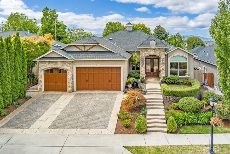 Welcome to a Pagnini masterpiece, where elegance meets functionality. Enter through 8-foot custom wood doors to a stunning open floor plan blending sophistication and comfort. At the heart is a gourmet kitchen is a large granite island, breakfast bar, high-end stainless-steel appliances, & two wine refrigerators. The space is illuminated by a skylight and features floor-to-ceiling Alderwood cabinetry w/ glass tiles. The kitchen boasts a 6-burner Petazzoni cooktop, double wall ovens, & granite countertops. The adjacent living room has vaulted ceilings, expansive windows, & a fireplace surrounded by custom cabinetry. The split floor plan offers privacy, w? a luxurious master suite opening to the serene back garden. The master bath includes a jetted tub, travertine shower, double vanity, & a spacious walk-in closet. 2 additional bedrooms share a Jack & Jill bathroom. The office features double walnut doors, built-in cabinets, and a view of Roxy Ann. 3-car garag