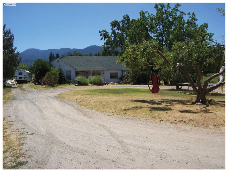 Sold Only...for statistical purposes only. 1950s farmhouse set on 3.14 level acres zoned RR-5 with adjoining 1.06-acre parcel, also zoned RR-5. The home retains some vintage character with wood floors and cozy living room fireplace with woodstove insert. The main level offers a spacious primary bedroom with an updated bath featuring wainscoting, vinyl flooring, a clawfoot tub, and a small shower, plus two guest bedrooms with knotty pine paneling and wood floors. The kitchen has laminate counters and vinyl flooring, with a large utility room and laundry sink nearby. Upstairs includes two additional rooms with built-ins. Outside has a large shop building with well, miscellaneous sheds and pasture areas ideal for animals and/or crops. The adjoining 1.06 has a greenhouse and gardening area.