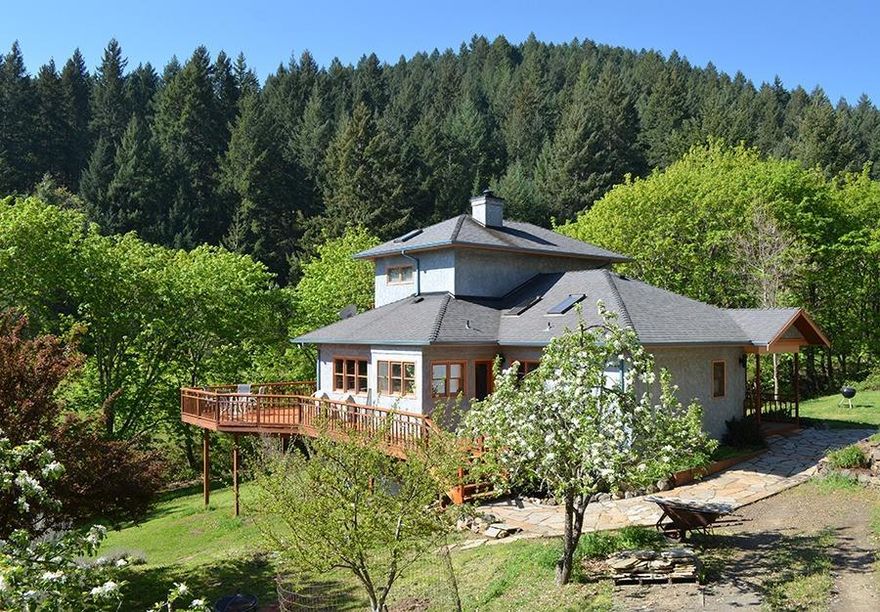 Priced to sell.   Enjoy tranquility on this lovely rural property just minutes from town. This custom home is situated on 20 acres with a seasonal creek & pond, established forest and views of Grizzly from the spacious deck. The beautiful landscaping surrounding the house is both deer and drought resistant. A newly drilled well (12+gmp) and 2000 gallon underground holding tank will provide plenty of water. The home is filled with custom woodwork throughout inc cherry cabinets, oak staircase & flooring and vaulted beadboard kitchen ceiling. A Kachelofen (masonry wood stove) serves as a hearth and separates the main floor living area. You will love to cook in the kitchen with the marble countertops, butcher block island, oversize stainless range and walk-in pantry. The sunlit master bedroom suite is on its own level with a separate deck and built in bookcase. Possible marketable timber on the property. Buyers to perform their own due diligence. A beautiful place to call home