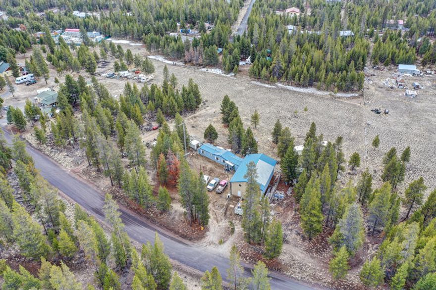 Bring your update ideas to this 2.16 Acre property with endless potential. Property currently features 1984 MF Home 840 sqft that has been moved twice and needs TLC to recapture its full potential. There is also a 1963 MF Home 520 sqft  for storage. Large, attached shop/garage has tons of room for all your cars & toys plus framed upper level for potential living quarters. Priced for cash offers, not likely to finance due to current condition and twice moved home.