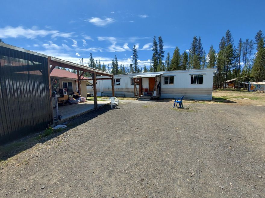 .99 acre with a Single Wide Manufactured Home and Large ADU, 2 In Ground Green Houses, 2 Red Wood Pole Barns- 1 w/ Redwood deck.  Large RR box car for additional storage! Room for RV parking/  Easy Access for all with a Round About Driveway. Includes Play Ground Area With Park Like Setting, Firepit & Basketball  Area In Front- Property is close to La Pines great hiking trails, fishing lake. Nature comes to your front yard, watch the bird and deer gather and play-Easy drive to all of Bend and Sun River's amenities!