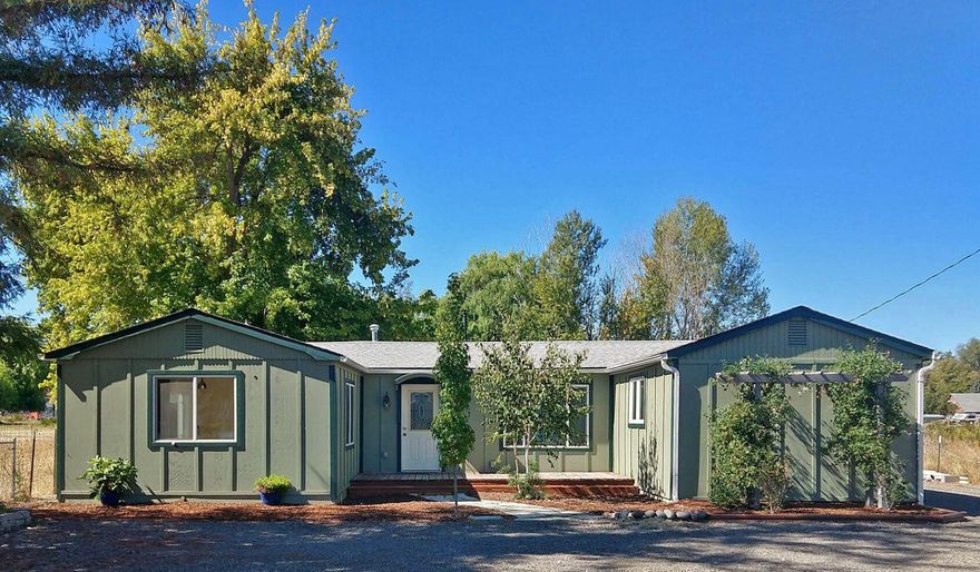 Move in ready & convenient to everything - this updated & bright house sits on half an acre with abundant natural light and quality finishes. The living area is open to a dine-in kitchen to live big on a conservative footprint, and triple panel french doors open onto a flagstone patio and hot tub where established trees add shade & privacy. Beyond the patio is a large lawn with raised garden beds and established fruit & nut trees. Clean interior with white trim, original (refinished) solid fir & new engineered oak floors in bedrooms & living area. Porcelain tile & stone floors in laundry/entry/bathrooms. Cabinets are alder and reclaimed tropical hardwoods with oil finish (matte look and very easy care). Undermount sinks in concrete counters at kitchen & guest bath (main bath has integrated ceramic top & sink), travertine tile shower with recessed niches for all the things. Built-in shelves & hanging rods maximize storage in closets & hall linen space. New exterior siding & new paint.