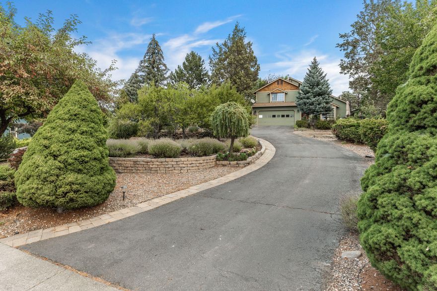 Do not miss out on this single owner property perched high on a quarter acre lot offering mountain views, great natural light, mature landscaping & privacy! This well-maintained property boasts a tall entry & vaulted ceilings in the Westerly facing living room. Bamboo floors lead into a beautiful, remodeled kitchen including premium custom cabinetry, granite counters, full tile backsplash & stainless appliances. Upstairs includes two guest bedrooms & a stunning remodeled guest bath w/tile vanity and tile shower. A primary bedroom offers westerly mountain views & updated primary bath complete w/heated floors & walk in tile shower. Enjoy summer evenings on the front or back private paver patios. Pick fresh fruit from one of the many fruit trees on the expansive property. Other updates include a 5 yr old roof, leaf guard gutter system, recently painted exterior, 2 garden sheds & water feature. Located just blocks from neighborhood park, and a short distance to Bend's medical centers.