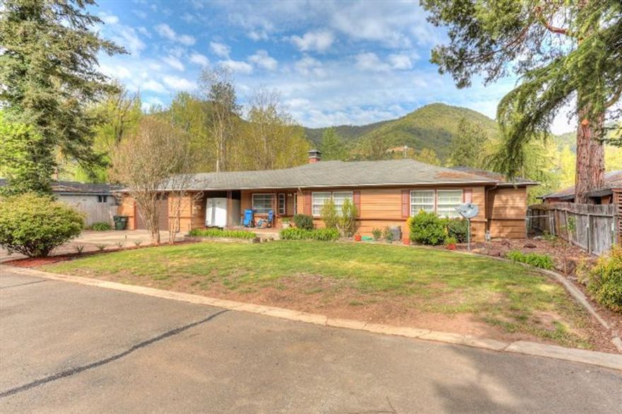 It's the view , the view , and what a view. This 1800+ sq ft 3 bedroom, 2.5 bath gated home sits on 100 feet of Rogue River frontage with just under an acre that gently slopes to the river. Tandem garage plus carport and lots of paved surfaces for RV, boat and other toys. Large covered patio to take in the view, greenhouse and separate laundry room with bathroom facilities. All new stainless steel appliances in the kitchen. 2 fireplaces, and wood paneled dining/family room that feels more like a mountain lodge. Large master with private bath and walk in closet. Guest bedrooms are huge and have walk in closets. Freshly painted inside and out with attractive updates . If you are looking for that river/mountain retreat where you can boat/fish off your own property with plenty of room for kids, pets and toys-this is it.