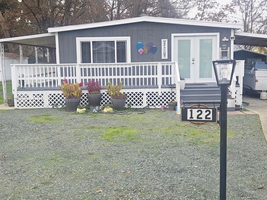 This home is completely Renovated from the roof to the floors in 2023 with Hawkeye Construction. It was interior decorated Country Modern Style. The open floor plan has the feel of twice the living space. The kitchen has a built in Microwave, range and oven, refrigerator is negotiable, custom cabinets with 2 lazy Susans, big drawers, breakfast/coffee bar with pantry shelfs, and a generous size custom built island with butcher block top and custom cabinets and drawers. The master bedroom is large with a walk-in closet. The second bedroom is moderate with a full-size closet. Entry through the custom front French doors with the blinds built inside the windows. It is well insulated with central air and heat.  The brand-new wraparound covered deck is sure to be a pleasure to entertain and just sit and relax and enjoy time in the big back yard. There is a newly built carport with a nice size shed for storage. This is a good community with friendly neighbors.