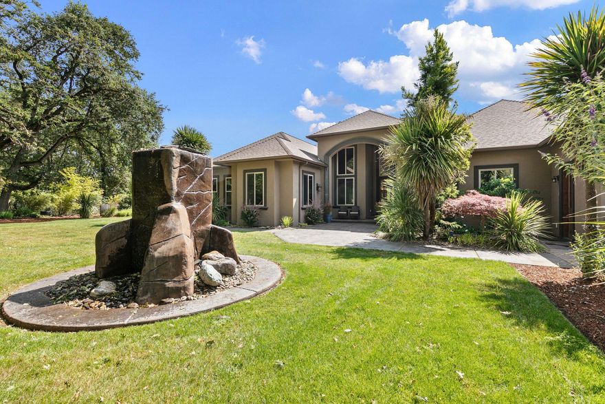 Welcome to this one-of-a-kind estate offering luxury, privacy, and stunning views. Situated on landscaped grounds with fenced pasture and pond for horses, this custom home blends high-end elegance with comfort. Enter through wrought iron gates to soaring ceilings, 12-ft wood pillars, and rich walnut floors flowing throughout. The chef's kitchen boasts custom walnut cabinetry, Mona Lisa granite, commercial cooktop, double ovens, built-in fridge, and walnut range hood, plus walk-in pantry. Open living areas feature stone fireplaces and 8-ft French doors framing mountain, backyard, and pool views. The primary suite offers a soaking tub, rain shower, granite counters, and custom walk-in closet. Outdoors, enjoy a heated pool with custom stone waterfall and slide, spa, fire pit, and multiple patios. The dedicated home theater includes plush recliners, premium sound, and 120'' screen. Additional highlights: climate-controlled 3-car garage with half bath.  Schedule your Private Tour Today!