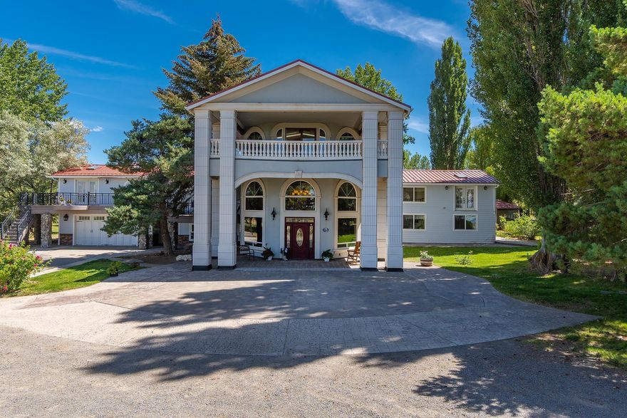 In the middle of this desert oasis is a stunning, awe inspiring, welcoming home that sits in the middle of 288 acres.  The property is bordered by 10s of thousands of acres of BLM land that provides endless recreational opportunities.  Follow the rose bush lined driveway to the solid front door with sidelights and transom.  View the expansive entry and vaulted ceiling with double stairways to the second floor.  This home boasts travertine tile, slate, and hickory, Belizean rosewood, black walnut, and juniper hardwood inlaid flooring throughout the rooms.  The kitchen is a cook's delight with the replica of an old wood cook stove and matching refrigerator, wall oven, warming oven, chef sink, plate rack, Lazy Susan, and appliance garage surrounded by hickory cabinets.  Large rooms throughout.  Comes with an incredible third floor apartment with French doors to balcony looking out over the grazing cattle in the pasture.  Native rock accents.  Only quality materials throughout this home.