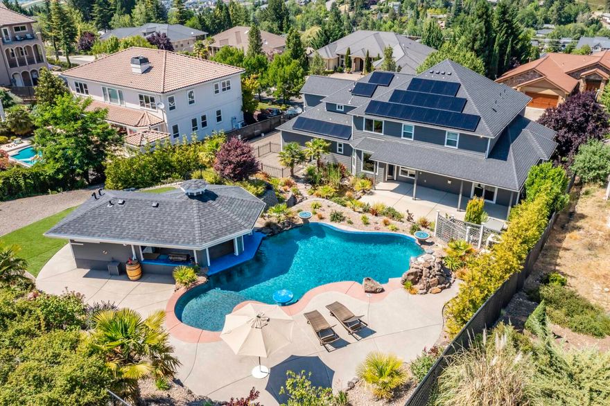 Exceptional views of Roxy Ann Mountain and the beautiful Rogue Valley. This gorgeous property is situated on a 0.49 acre estate lot among other high-end homes. Finishes include but aren't limited to granite counters, hardwood and tile floors as well as stainless steel appliances. The kitchen, living room, dining room, main bedroom suite, office/den, and laundry are all on the main level. Upstairs boasts a huge bonus room, a second master suite, with two additional bedrooms. Large exercise studio could be utilized as a fifth bedroom. Needing more space? There are four walk-in storage closets as well as attic and under house storage. After a long day, escape to the large multi-level backyard where you'll feel as if you're on vacation. Breathtaking custom pool with a swim up bar and covered outdoor kitchen with full bathroom. This custom pool house has everything you could imagine! Seller invested approx. $400,000 on pool and outdoor living space.