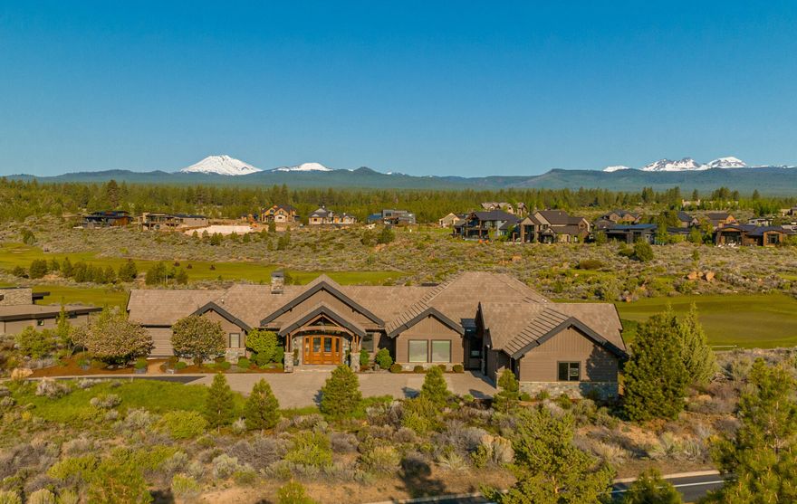 Elegant, yet undeniably welcoming. Dramatic but still imminently tranquil & private. All of this, and more, intertwine to give this luxurious custom built house the inherent comfort of home. 19.5' ceilings and floor to ceiling windows in the great room draw the eye across greens & fairways of Tetherow golf course to magnificent Cascade Mtn. views as your backdrop. Unlock your culinary genius in a chef's kitchen with an induction cooktop, large island with prep sink & walk-in pantry with a 3rd sink & loads of storage. Three ensuite bedrooms including a primary suite with a 15' vaulted ceiling as a gateway to mountain views, a generous bathroom with soaking tub & walk-in tile shower and heated floors. Beautifully appointed flex room features Cascade Mtn. views, private bathroom, built-ins, fireplace & vaulted ceilings. Enjoy those spectacular views from a private covered patio with stone fireplace & in ground spa with fire bar, buffered by natural scape common space on this .89 acre lot.