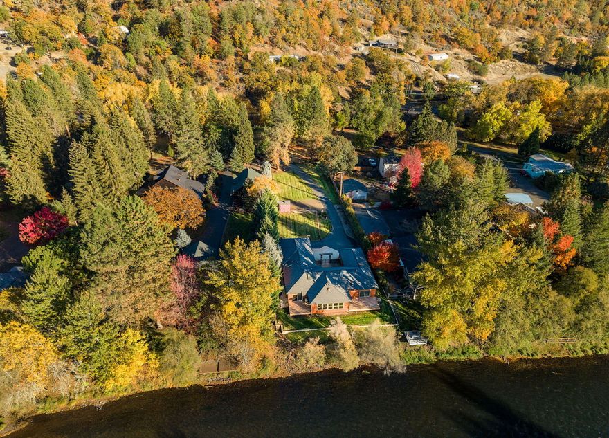 Custom built home on 1.29 acres offers gorgeous Rogue River frontage, a spacious single level layout, huge kitchen, 2 primary suites, walk-in cold storage, beautiful grounds, fenced garden, irrigation and ample room for an RV or boat. The home was thoughtfully designed and extensively upgraded. The spacious kitchen includes a large island, natural gas cook top, Jen-Air and GE appliances, double ovens and abundant cabinet space. The main primary suite overlooks the river, has its own private Trex deck, a large ensuite with heated tile floors, walk-in tile shower, soaking tub and a walk-in closet. The floor plan also includes a bonus room overlooking the river and a huge laundry room with tons of storage. Extras include a central vac, solid core doors, high-end windows with lifetime guarantee, never-paint Hardi siding, dual fuel furnace, a sauna, hot tub, ample storage, 2 gas fireplaces, internal sound system and more. Extremely comprehensive property on a gorgeous stretch of the Rogue!