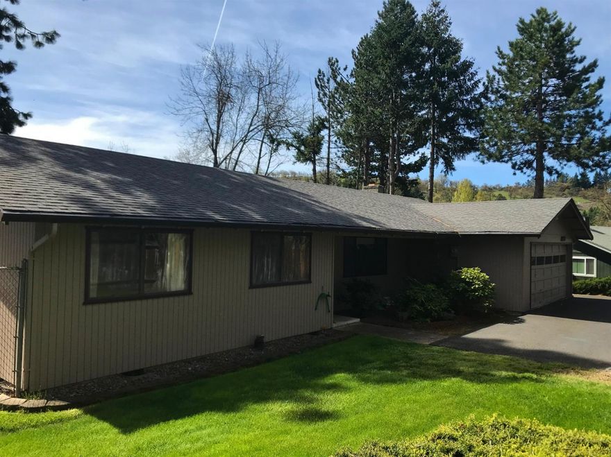 This single level home in East Medford features 3 bedrooms, 2 baths, living room plus a family room with a brick fireplace and French doors leading to the large Trex style deck with custom railing, garden area, mature trees and foliage. Seller states there are some recent updates including a newer heat pump, some of the rear windows and the roof was replaced a while back. There is even some room for RV parking. Home sits on flag lot off Angelcrest Dr.