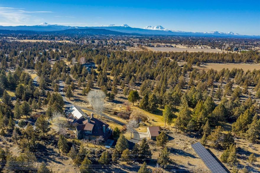 This one of a kind home sits on 14.97 gorgeous acres at the end of Los Serranos Drive, just minutes away from downtown Bend. Featuring spectacular Cascade Mountain and Smith Rock views, this amazing property features a separate pool house with retractable roof, full kitchen, bathroom and showers. The mid-level includes a kitchen with large pantry and views of the Cascade Mountains, multiple living areas, office, full bath and bedroom. The upper level includes a master suite with private patio, two bedrooms with Jack & Jill baths and upper crow's nest viewing deck. The lower level includes two bedrooms, bath with living area/in-law, possible nanny's quarters. With two water features, a pond, fruit bearing trees, a shop, solar panels, 1.90 acres of COI irrigation, and no HOA fees, this beautiful property is a must see!