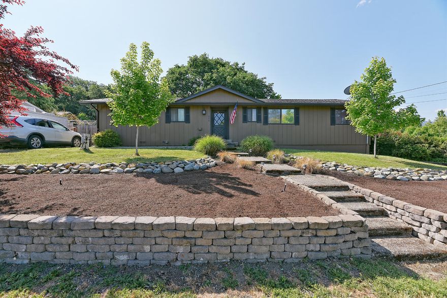 Come see this cozy corner lot home in the heart of Phoenix with lovely mountain views.  You'll find hardwood floors running throughout home with oversized windows in the living room, providing lots of natural light, an exposed brick hearth that is perfect for an electric fireplace. The open concept kitchen is stacked with cabinets & lots of counter space for all your cooking accessories. New roof in 2020 and home was recently painted on the exterior. Home has 4 bedrooms, two full baths, with main bath having access to a bedroom. The 4th additional room is oversized with large sliding windows & could be considered a family room. It has a sink & burner stove, making it possible for a private office. Two sets of sliding glass doors open to a private backyard with mature trees and beautiful landscaping. Separate entrance to the downstairs two car. Driveway is wide enough for parking an RV, and has electrical hook ups. Back yard is very private and looks like a small park.