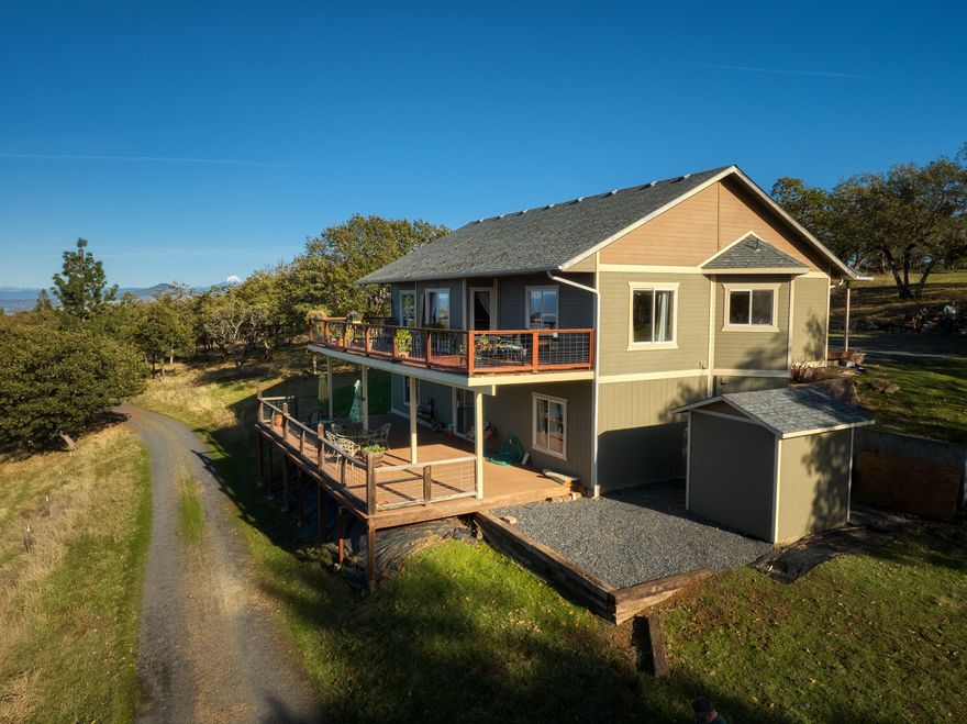 Hilltop Seclusion with views across the Valley. Minutes from Jacksonville with paved road all the way to the drive. Over 36 acres to ensure your privacy. 2911 sqft., 3 bed 2 1/2 bath, office (that could be made into a fourth bedroom,) primary suite on entrance level, great room layout, high ceilings, with magnificent views. Two large decks to take in the scenery and plenty of room for your horses or 4H/FFA projects as well as extra space for your garden. Large shop (1760 sqft.) with roll up door, office, loft, and bathroom. Shop has room for multiple cars, or could be used as a studio.  Buyer to do their own due diligence regarding possible uses and future development of this property. This property is NOT a drive-by, appointment required.